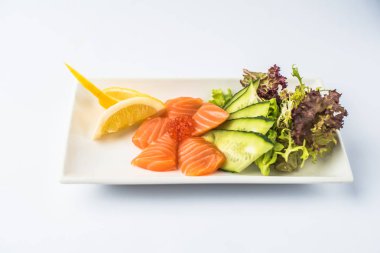 Kırmızı havyar ve beyaz arka plan üzerinde tabakta servis sebze taze somon balığı