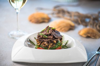 Beyaz tabakta et ve sebze yemek