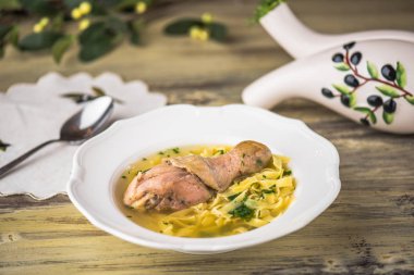 Tavuk çorbası erişte ile ahşap masa beyaz tabakta servis