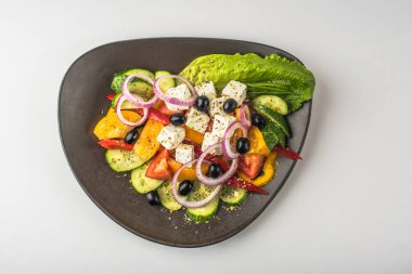 Beyaz arka plan üzerinde kase taze sebze Yunan salatası