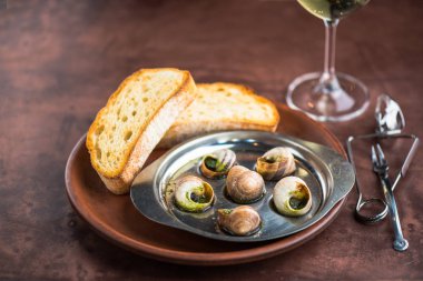 Tost ve şarap ile yağda pişmiş salyangoz