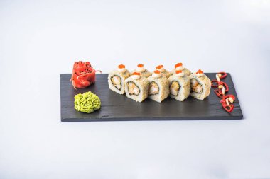 Kayrak beyaz zemin üzerine kırmızı havyar ile süslenmiş Japon suşi roll servis