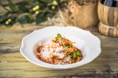 Ahşap masa üzerinde beyaz tabakta servis domates soslu makarna çeşitleri