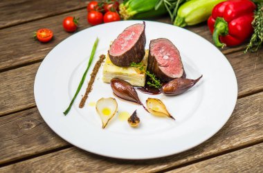 Ahşap masa üzerinde beyaz plaka üzerinde ızgara soğan ile balık