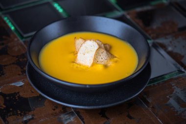 Siyah kase croutons süslenmiş krem balkabağı çorbası