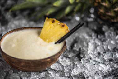 Hindistan cevizi sütü ve buz ile koyu arka plan bardakta ananas kokteyli