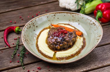 Soslu patates püresi ve havuç plaka üzerinde ahşap masa ile kavrulmuş et