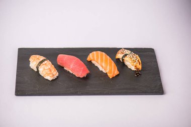 lezzetli nigiri suşi gri arka plan üzerinde kayrak gemide görmek