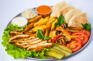 Beyaz arka plan üzerinde metal plaka üzerinde tabak yemek oryantal tarzı - kızarmış eti, ızgara biber, pide, domates, salatalık, patates, Humus, soslar