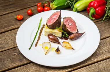 Ahşap masa üzerinde beyaz plaka üzerinde ızgara soğan ile balık