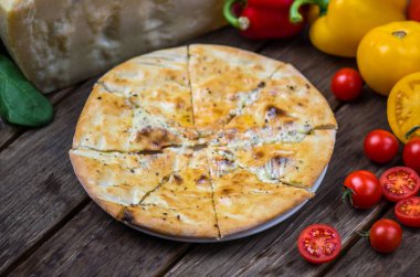 Ahşap masa üzerinde plaka üzerinde İtalyan pizza peyniri ve krema sos ile servis