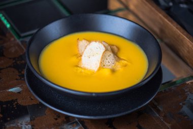 Siyah kase croutons süslenmiş krem balkabağı çorbası