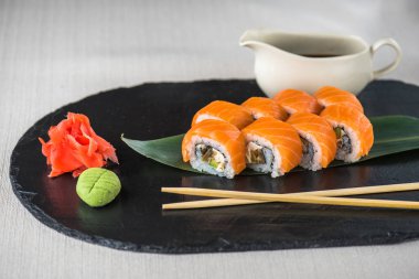 Japon Suşi roll kayrak üzerinde çubuklarla hizmet.