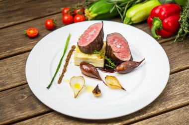 Ahşap masa üzerinde beyaz plaka üzerinde ızgara soğan ile balık