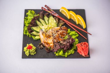 Beyaz arka plan üzerinde tabakta taze yılan balığı sashimi sebze ile servis