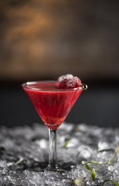 Martini cam Berry kokteyl buz ile koyu arka plan üzerinde dondurulmuş ahududu ile süslenmiş
