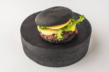 Parça ahşap beyaz arka plan üzerinde siyah sığır eti burger hizmet
