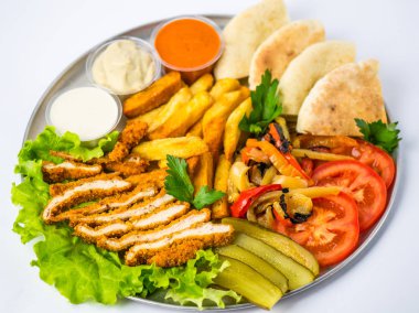 Beyaz arka plan üzerinde metal plaka üzerinde tabak yemek oryantal tarzı - kızarmış eti, ızgara biber, pide, domates, salatalık, patates, Humus, soslar