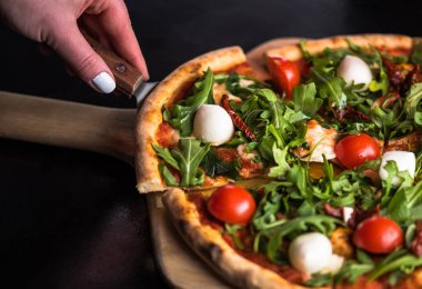 dilim taze domatesli pizza alarak el roka ve mozzarella peyniri