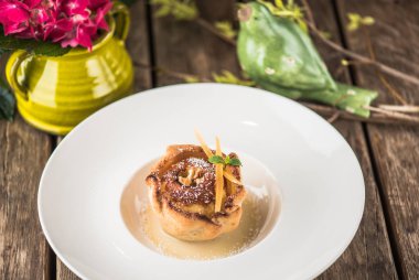 Beyaz plaka üzerinde gül şeklinde pişmiş pasta