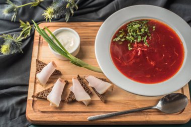 Ekmek ve domuz eti yağ ile ahşap tahta üzerinde haşlanmış Pancar çorbası plaka servis