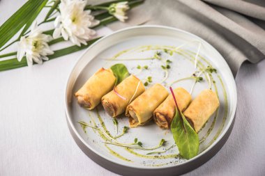 Doldurulmuş Krep çiçeklerle beyaz masa örtüsü tepside servis haddelenmiş