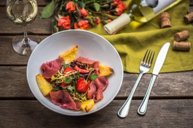 İştah açıcı jambon, çilek ve filizi kase ahşap tablo