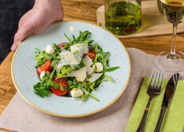 Ahşap masa üzerinde plaka üzerinde peynirli taze sebze salatası