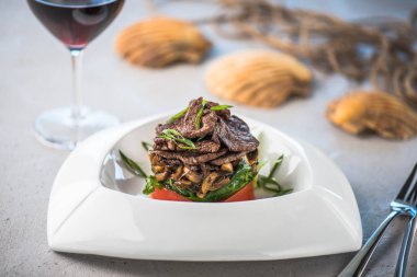 Beyaz tabakta et ve sebze yemek