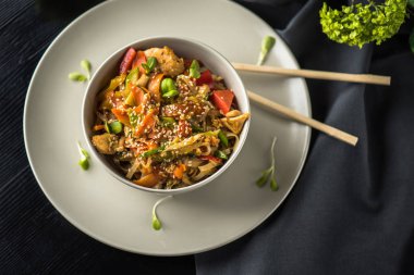 Siyah kumaş üzerine yemek çubukları ile plaka üzerinde Asya kase erişte