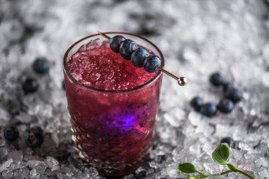 Stick buz ile koyu arka plan üzerinde yaban mersini taze kokteyl cam süslenmiş