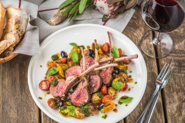 Eti fileto malzemelerle ahşap masa üzerinde plaka üzerinde soslu sebzeli kemikleri üzerinde