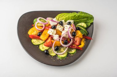 Beyaz arka plan üzerinde kase taze sebze Yunan salatası