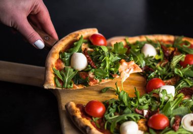 dilim taze domatesli pizza alarak el roka ve mozzarella peyniri