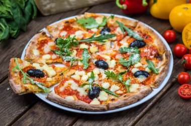 Roka ve ahşap masa tabakta servis zeytin İtalyan pizza