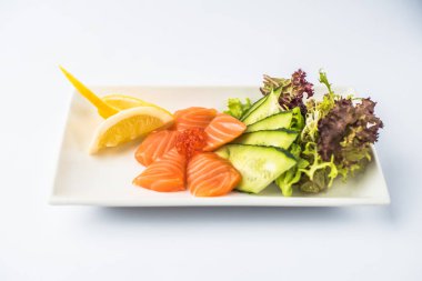 Kırmızı havyar ve beyaz arka plan üzerinde tabakta servis sebze taze somon balığı