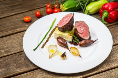 Ahşap masa üzerinde beyaz plaka üzerinde ızgara soğan ile balık