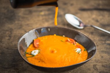 ahşap masa üzerinde sürahi kase içinde peynirli sebze çorbası bırakarak