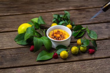 Narenciye tatlı limon, çilek ve ahşap masa yapraklar ile fincan