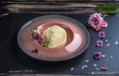 Ahşap masa üzerinde yenilebilir çiçekler ile dekore edilmiş patates püresi bölümünü