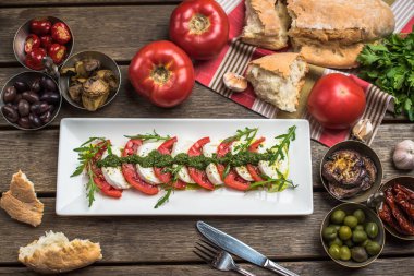 Aperatifler ve malzemelerle ahşap masa tepside servis geleneksel İtalyan caprese salatası