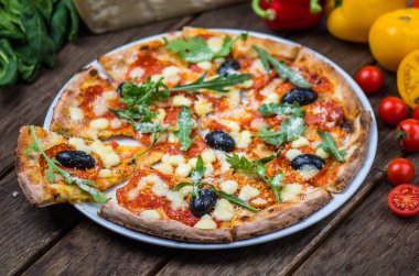 Roka ve ahşap masa tabakta servis zeytin İtalyan pizza