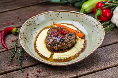 Soslu patates püresi ve havuç plaka üzerinde ahşap masa ile kavrulmuş et