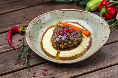 Soslu patates püresi ve havuç plaka üzerinde ahşap masa ile kavrulmuş et