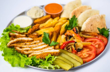 Beyaz arka plan üzerinde metal plaka üzerinde tabak yemek oryantal tarzı - kızarmış eti, ızgara biber, pide, domates, salatalık, patates, Humus, soslar