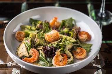 Tabak koyu arka plan üzerinde ızgara karides ile sebze salatası