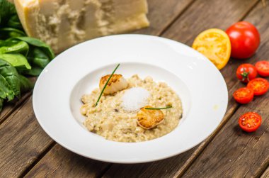 Ahşap masa üzerinde beyaz tabakta servis tarak ile İtalyan risotto