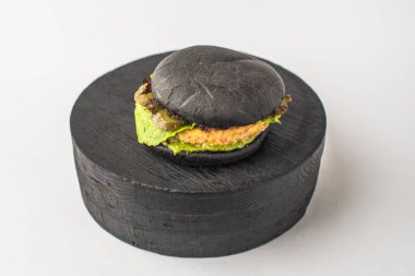 Parça ahşap beyaz arka plan üzerinde siyah sığır eti burger hizmet