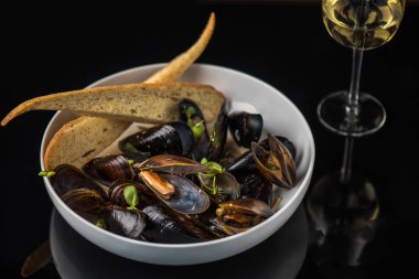 Koyu arka plan üzerinde ekmek ile yağda pişirilmiş midye kase