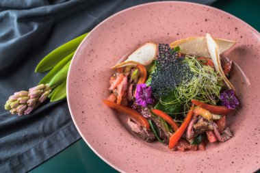 Çiçekli pembe plaka üzerinde meze et ve sebze ile servis